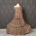 Traditional embroidered outfit on a mannequin against a textured gray wall BRIDAL LEHENGA INDIAN MACHINE WORKI N PAKISTAN PRICE
