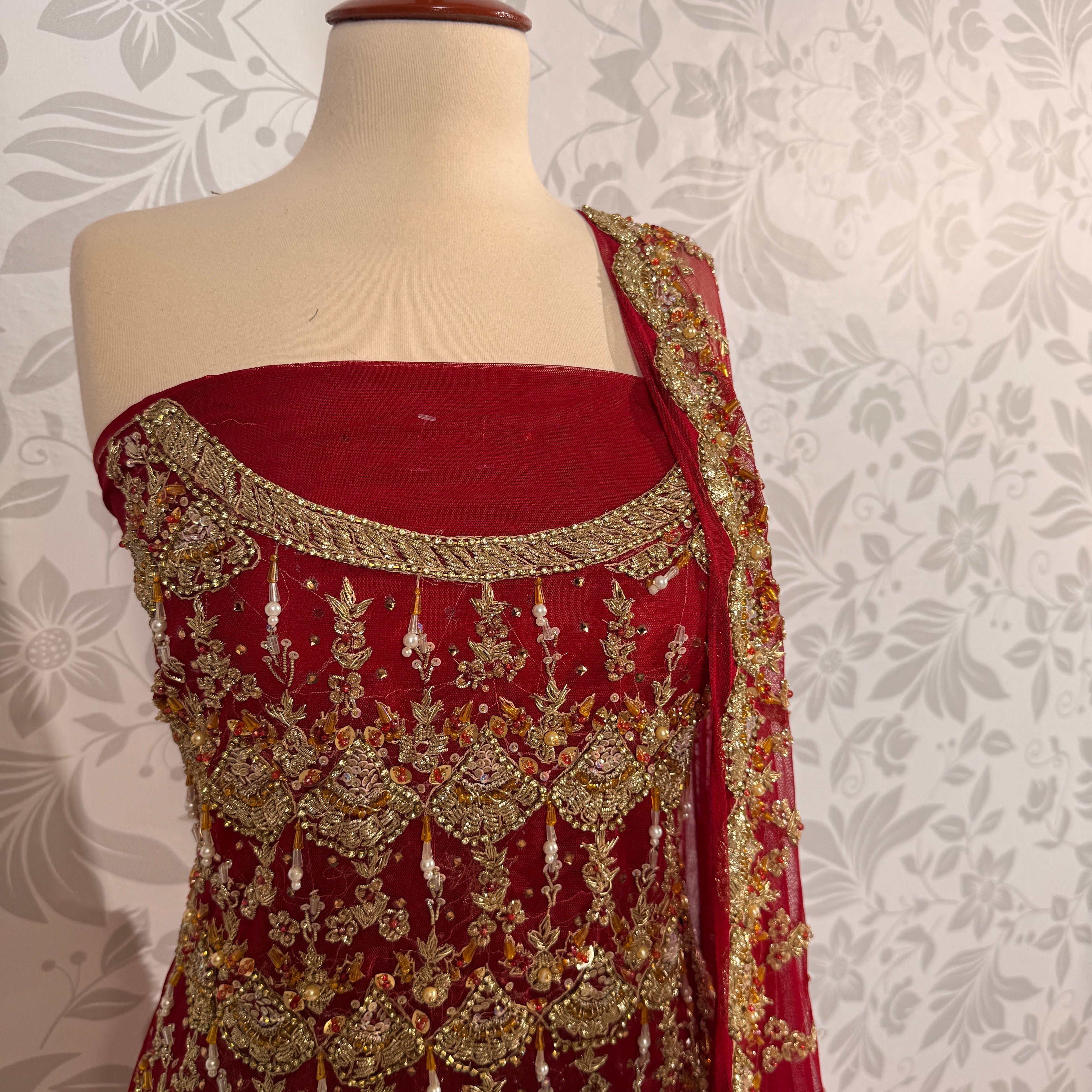 Bridal lehenga Pakistani BL027 shirt close up – dabka jewelry work and hanging pearl detail on deep anari red crinkle chiffon fabric
