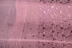 A close-up of a pink sheer fabric with metallic silver floral embroidery and sequins, showing both the plain and patterned sides.