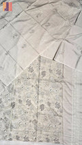 A light beige or off-white fabric garment laid flat, featuring delicate floral embroidery and a decorative border. The fabric has a warm, slightly cream undertone, which maps best to Beige in the allowed color palette.