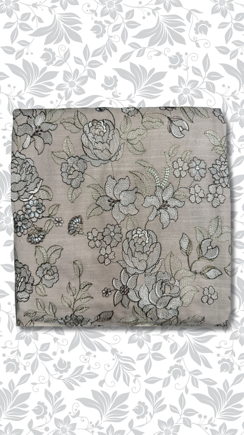 A folded piece of taupe fabric featuring an intricate black and gray floral embroidery pattern, presented against a white background with a matching gray floral watermark overlay.