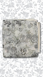 A folded piece of light gray fabric with a black floral line-art pattern, displayed against a white background with a matching gray floral watermark pattern.