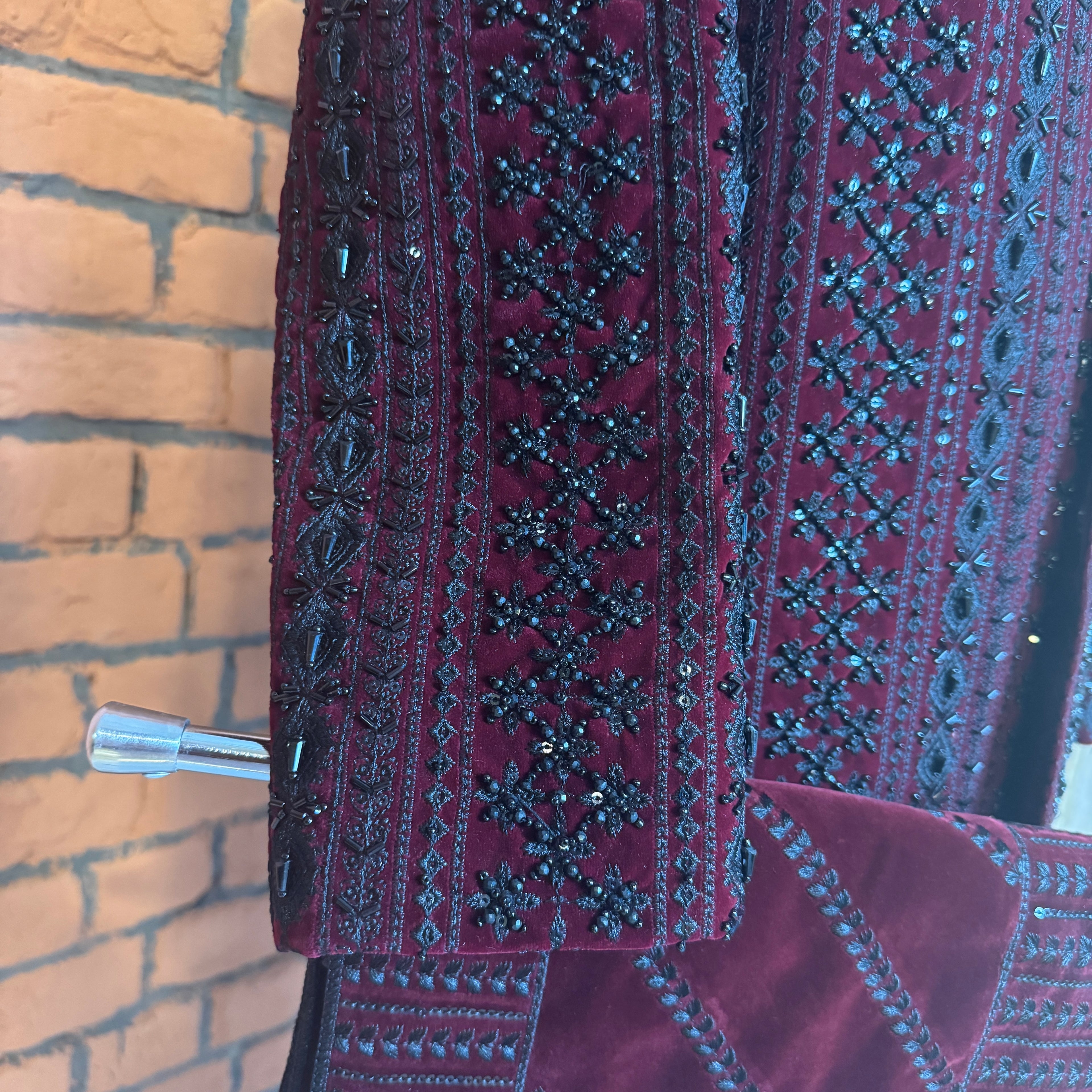 sherwani for men maroon fabric and embroidery texture close-up
