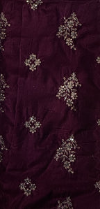 Deep maroon velvet fabric with silver and white floral embroidery and beadwork.